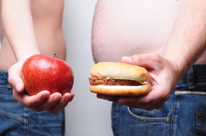chudý drží jablko a tlstý drží hamburger